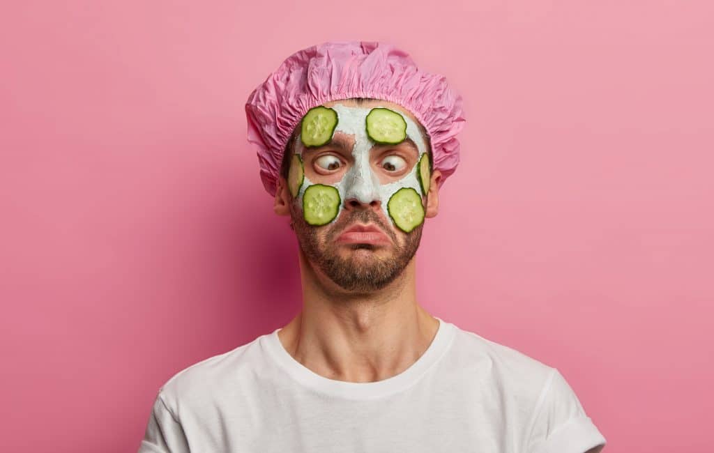 Homme se faisant un masque pour homme avec des concombres. 
