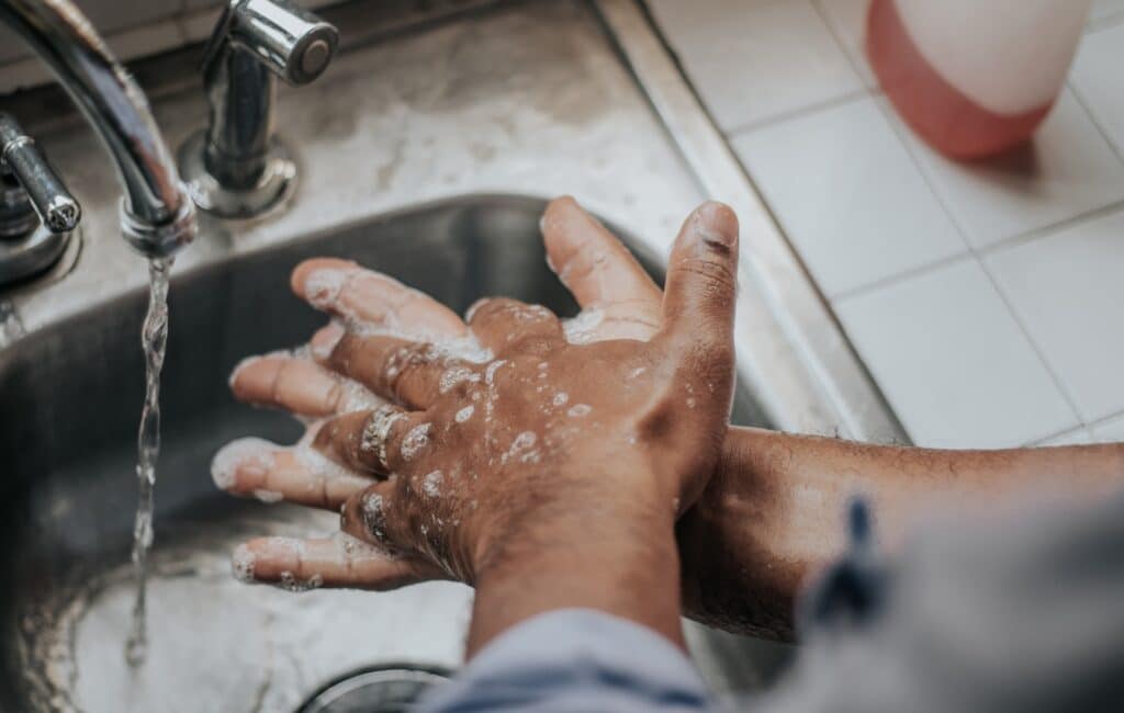 Personne se lavant les mains dans un lavabo afin d'éviter de tomber malade