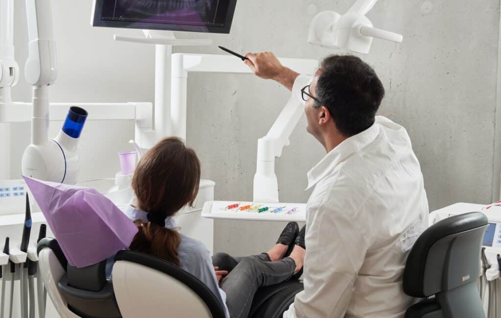 Dentiste montrant à sa patiente son alignement des dents avec l'aligneur Invisilign