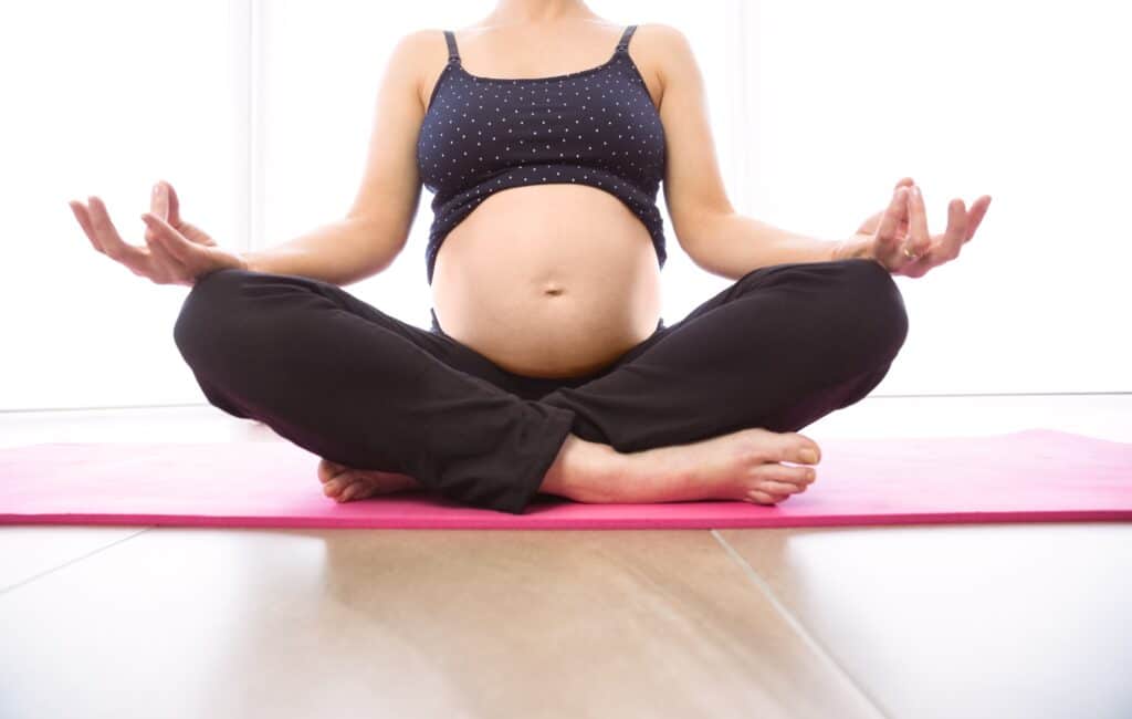 Femme enceinte qui fait du yoga